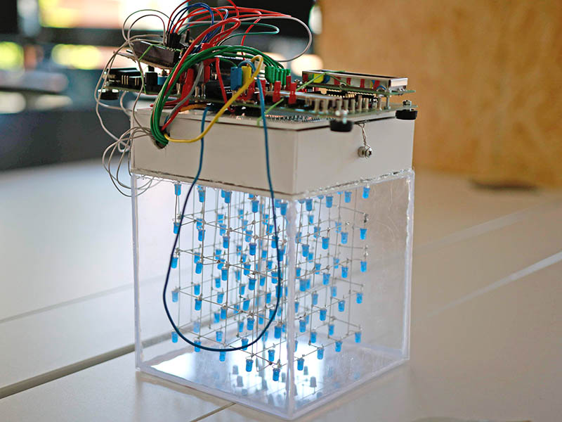 Ein Würfel aus Plexiglas mit darin hängenden LEDs.